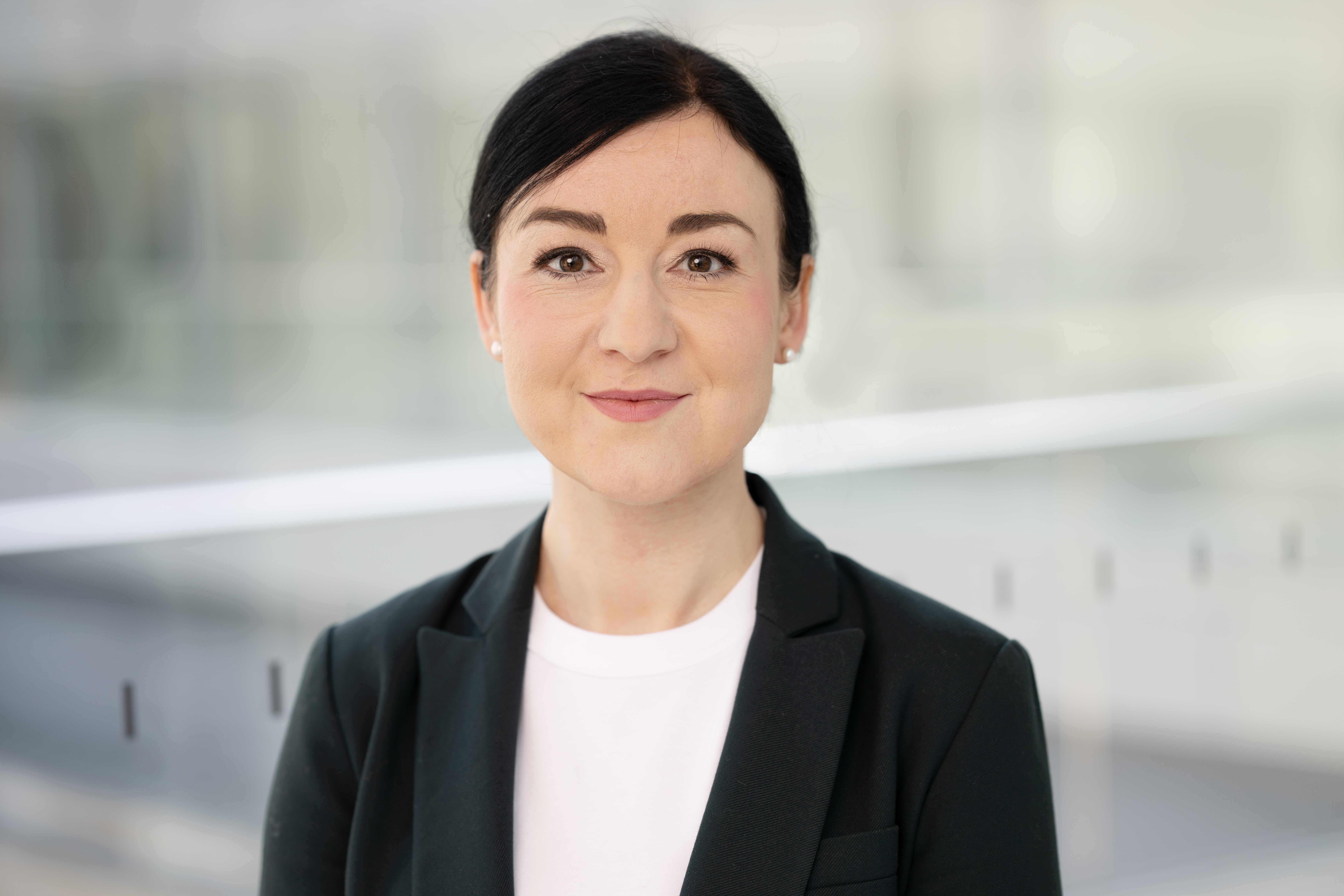 vor neutralem Hintergrund ist eine Frau abgebildet.